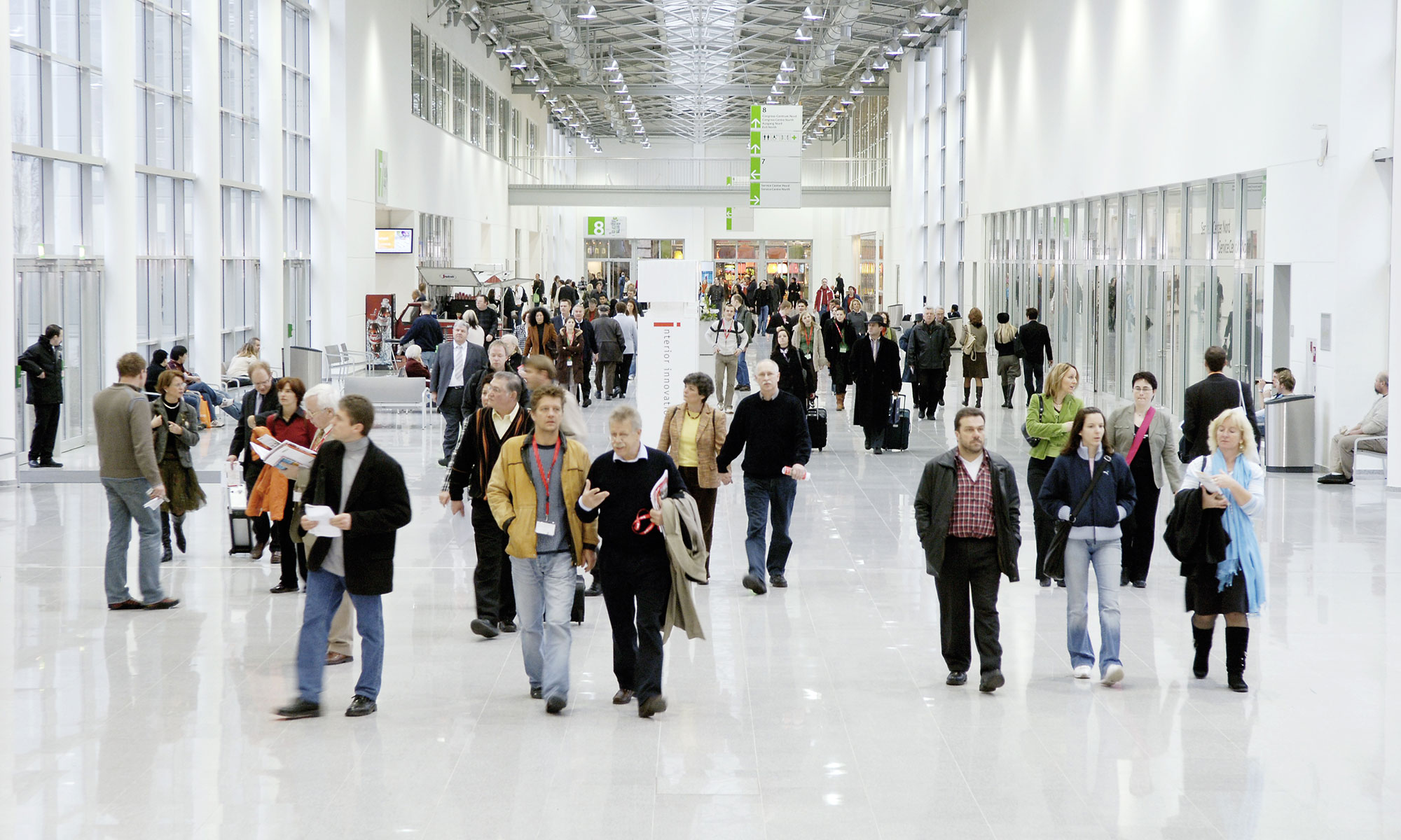 Menschen gehen durch den Messeboulevard der Koelnmesse