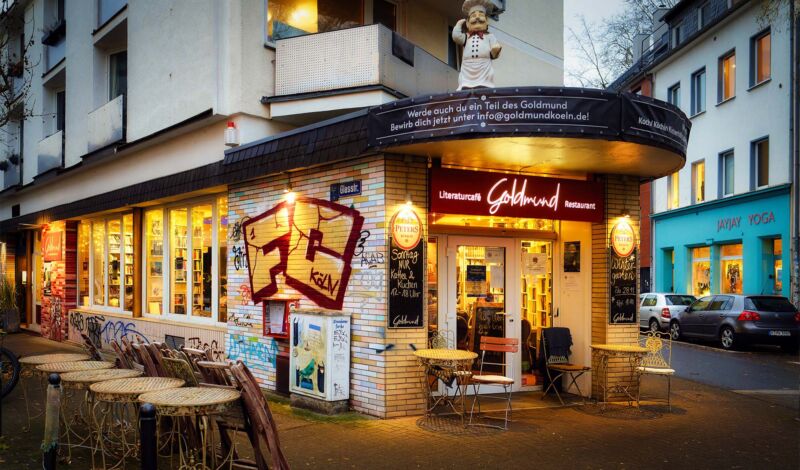Außenansicht des beleuchtetetn Literaturcafés Goldmund in der der Dämmerung