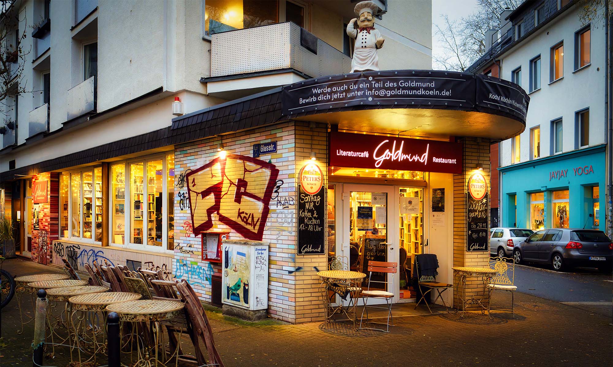 Außenansicht des beleuchteten Literaturcafés Goldmund in der der Dämmerung