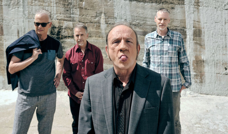 Die vier Musiker der Band The Jesus Lizard stehen in einem Steinbruch.