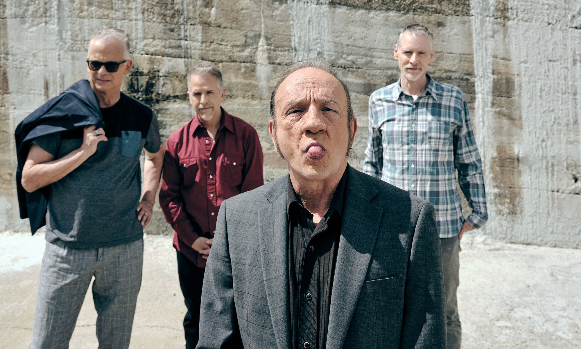 Die Vier Musiker der Band The Jesus Lizard stehen in einem Steinbruch.