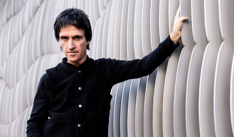 Der britische Songwriter und Gitarrist Johnny Marr lehnt an einer Wand.