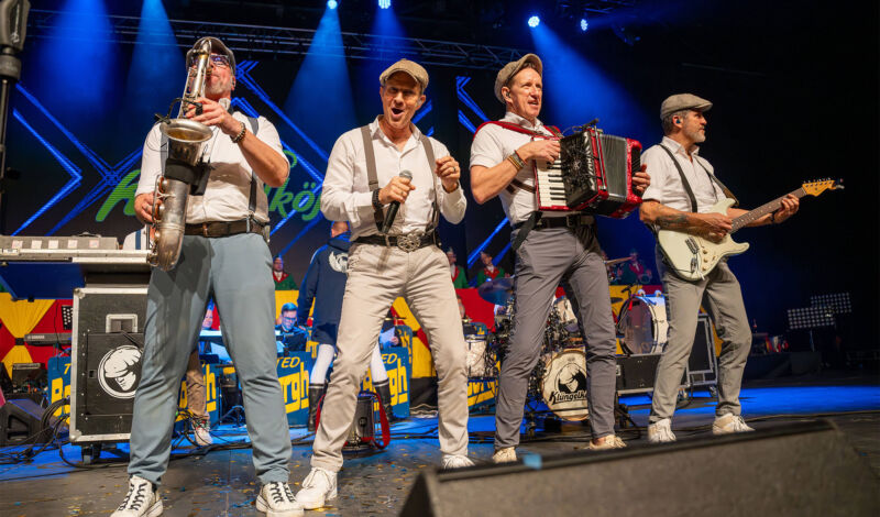 Musiker der Kölner Band Klüngelköpp stehen in einem Konzert auf der Bühne
