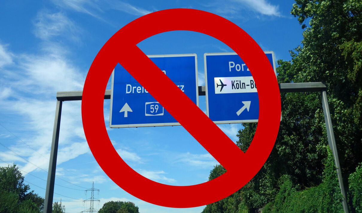 Ein Schild auf der Autobahn 59 bei Köln, welches von einem Verbotszeichen überdeckt ist.