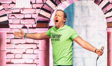 Der Comedian Mario Barth in einem grünen T-Shirt auf der Bühne.
