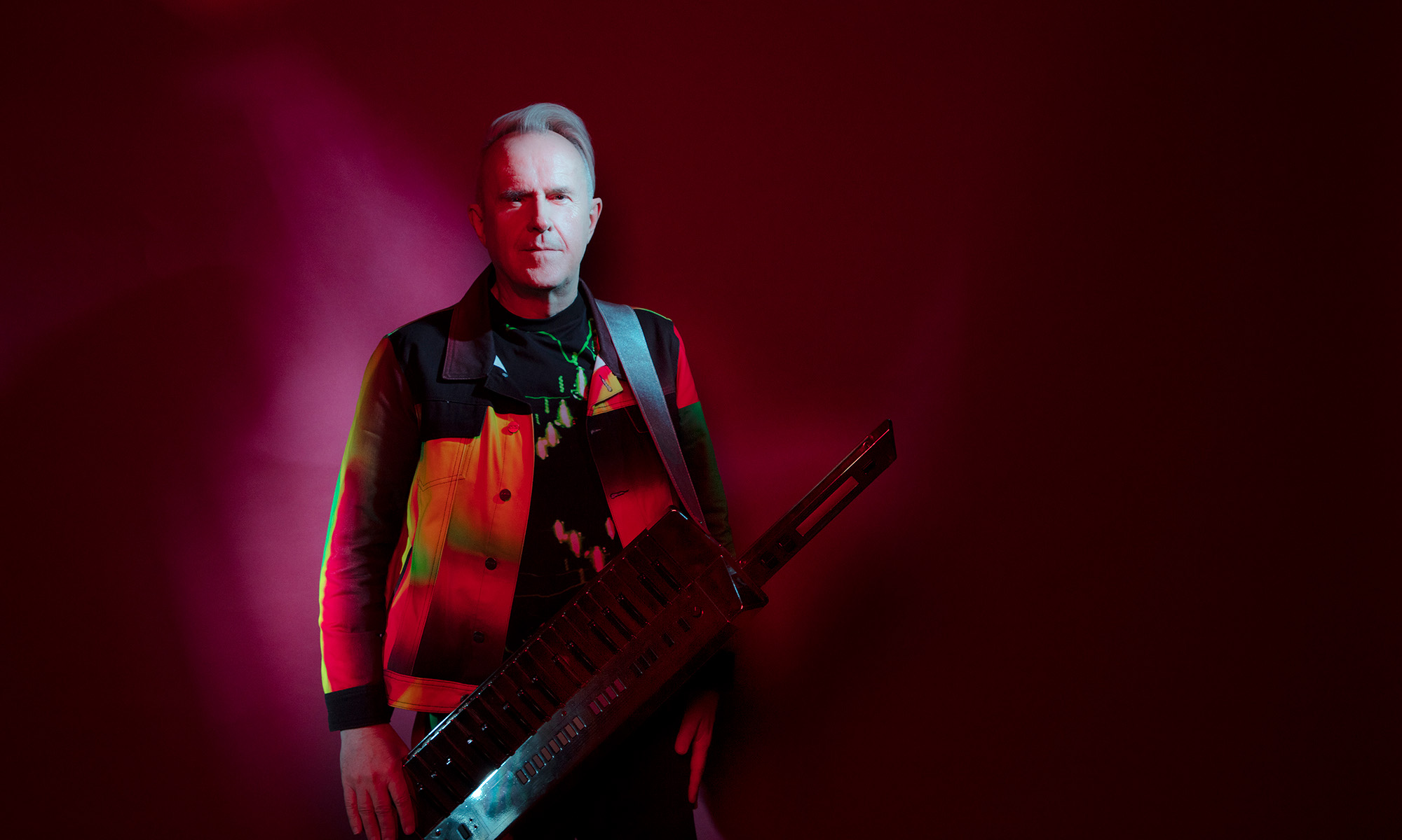 Der britische Musiker Howard Jones in rotem Licht.