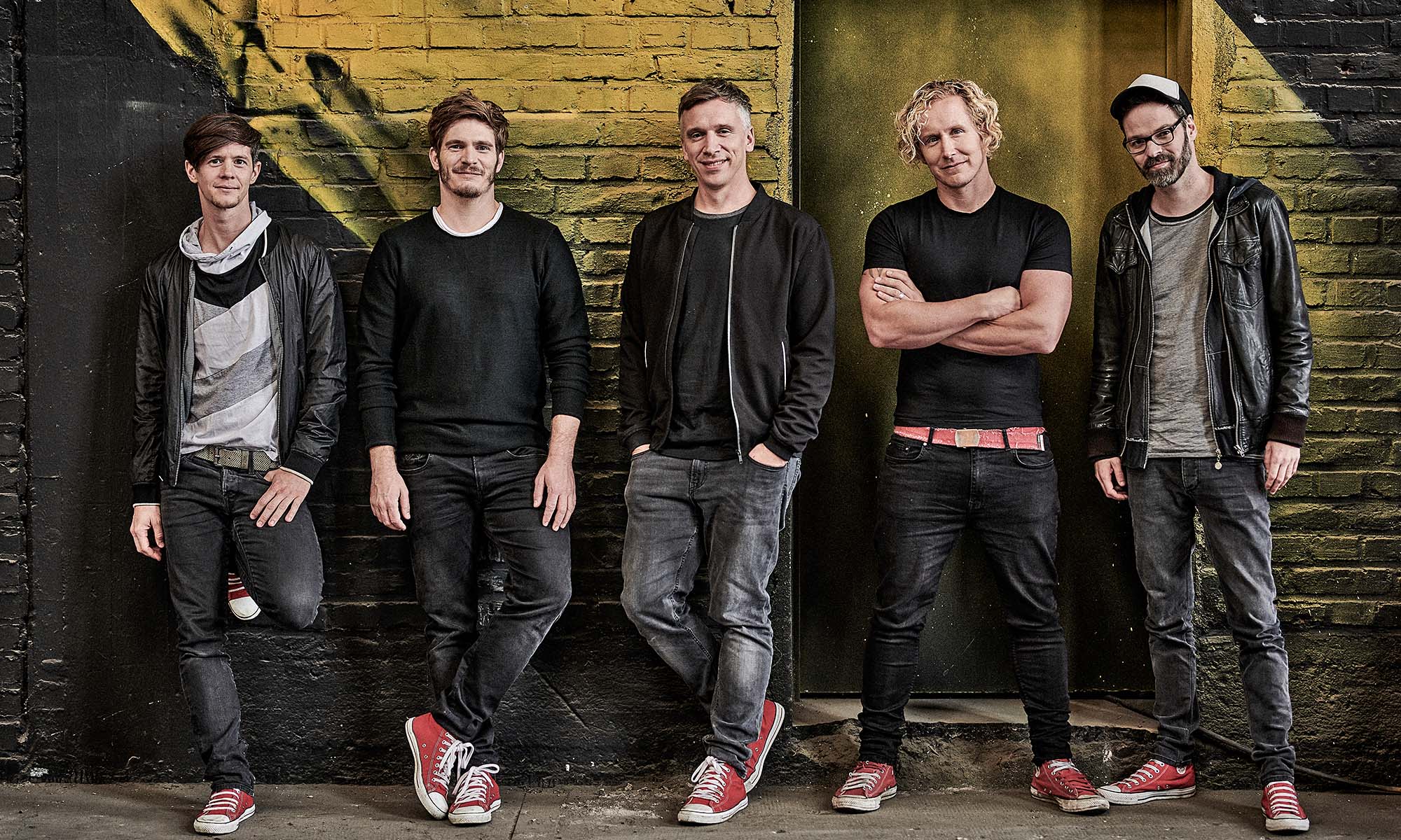 Die Musiker der Kölner Band Kasalla lehnen an einer Wand.
