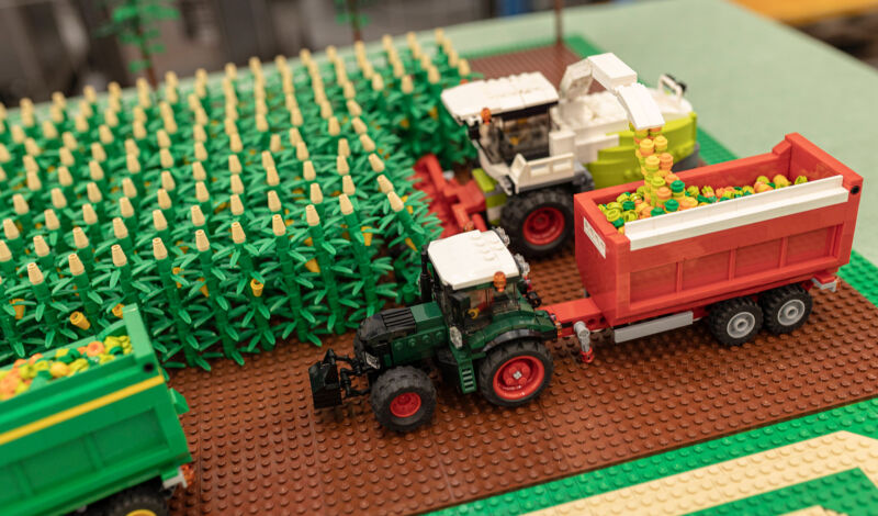 Eine aus Lego-Steinen gebaute Szene zeigt wie ein Mähdrescher ein Mais aberntet.