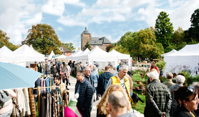 Weiße Zelte der Herbstpartie, im Hintergrund ein Burgturm