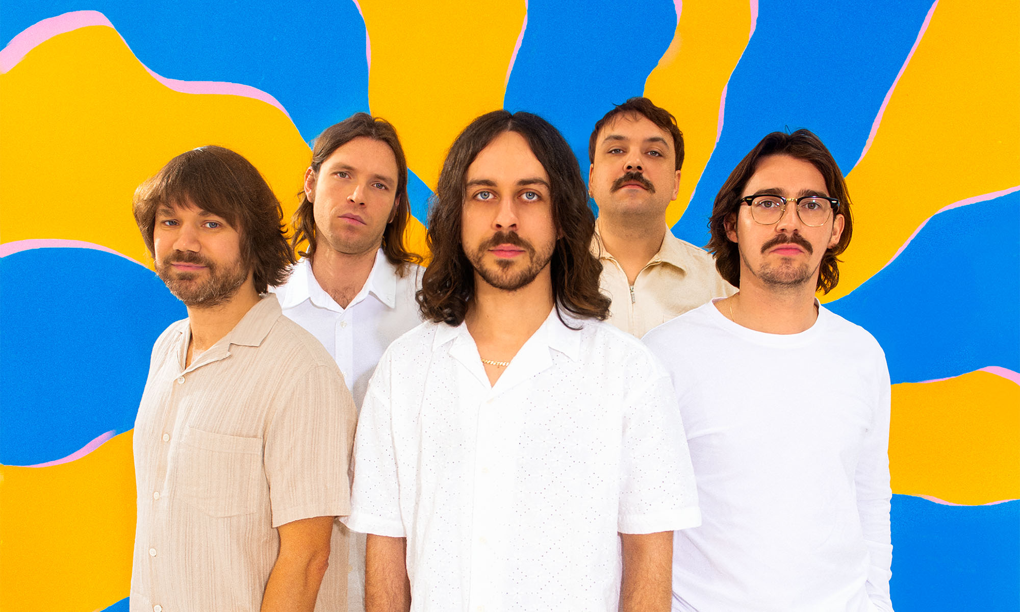 Die fünf Musiker der niederländisch-türkischen Rockgruppe Altın Gün vor blau-gelbem hintergrund.