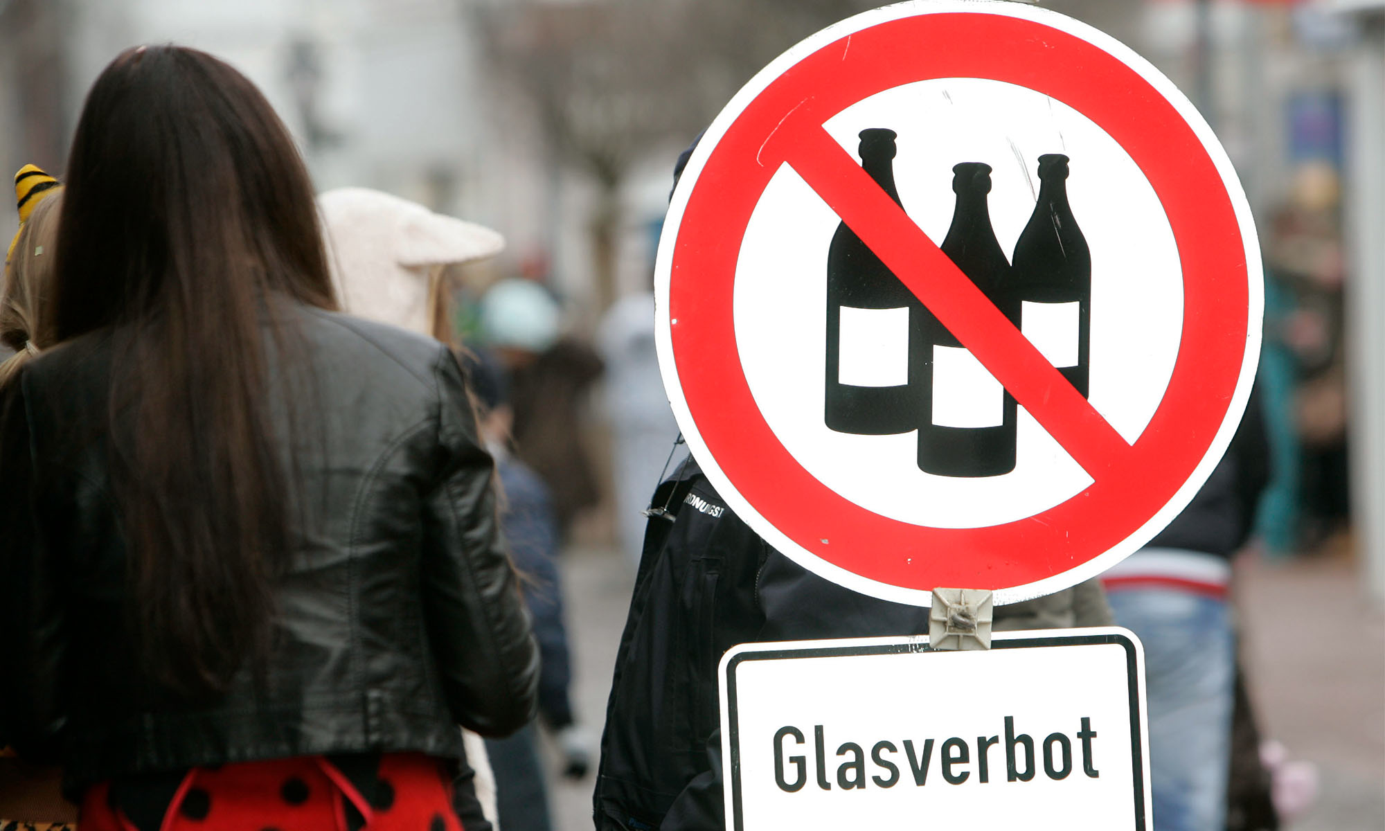 Ein Schild weist auf das Glasverbot an Karneval hin.