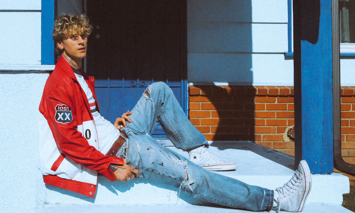 Der Sänger mgk (ehem. Machine Gun Kelly) sitzt auf einer Haustreppe.