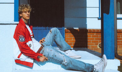 Der Sänger mgk (ehem. Machine Gun Kelly) sitzt auf einer Haustreppe.