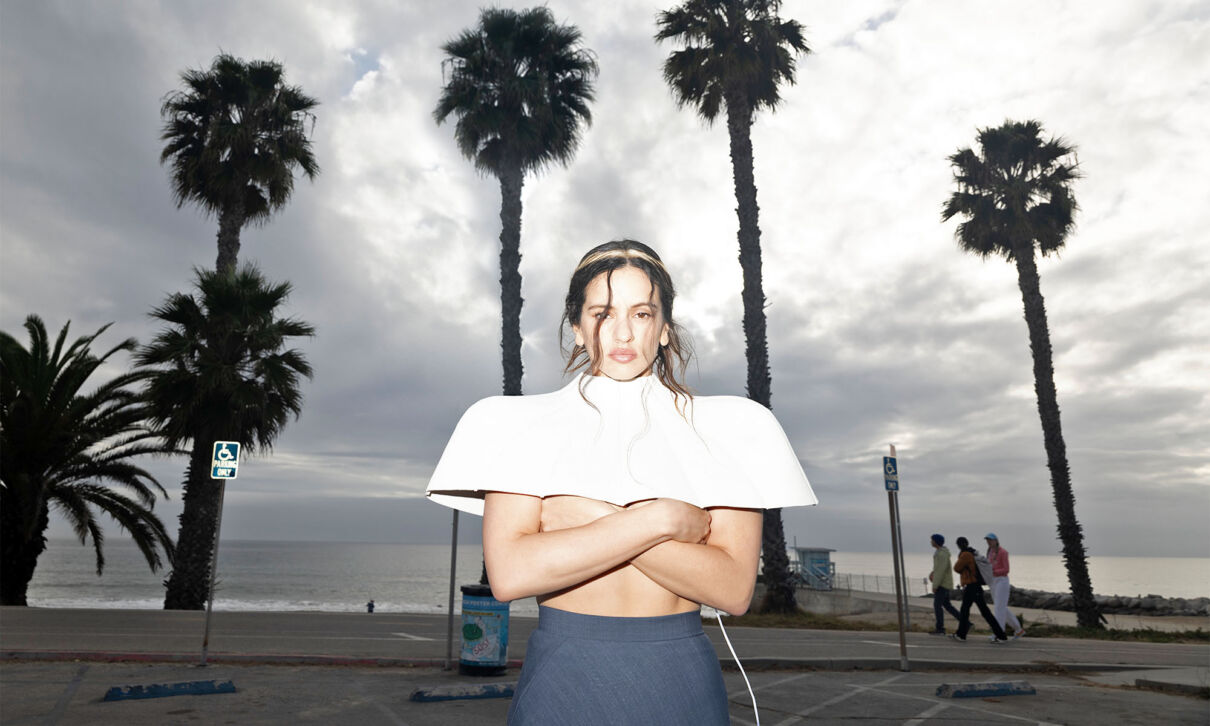 Die spanische Sängerin Rosalía steht vor Palmen.