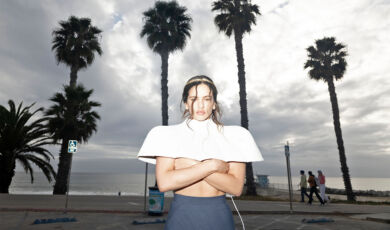 Die spanische Sängerin Rosalía steht vor Palmen.