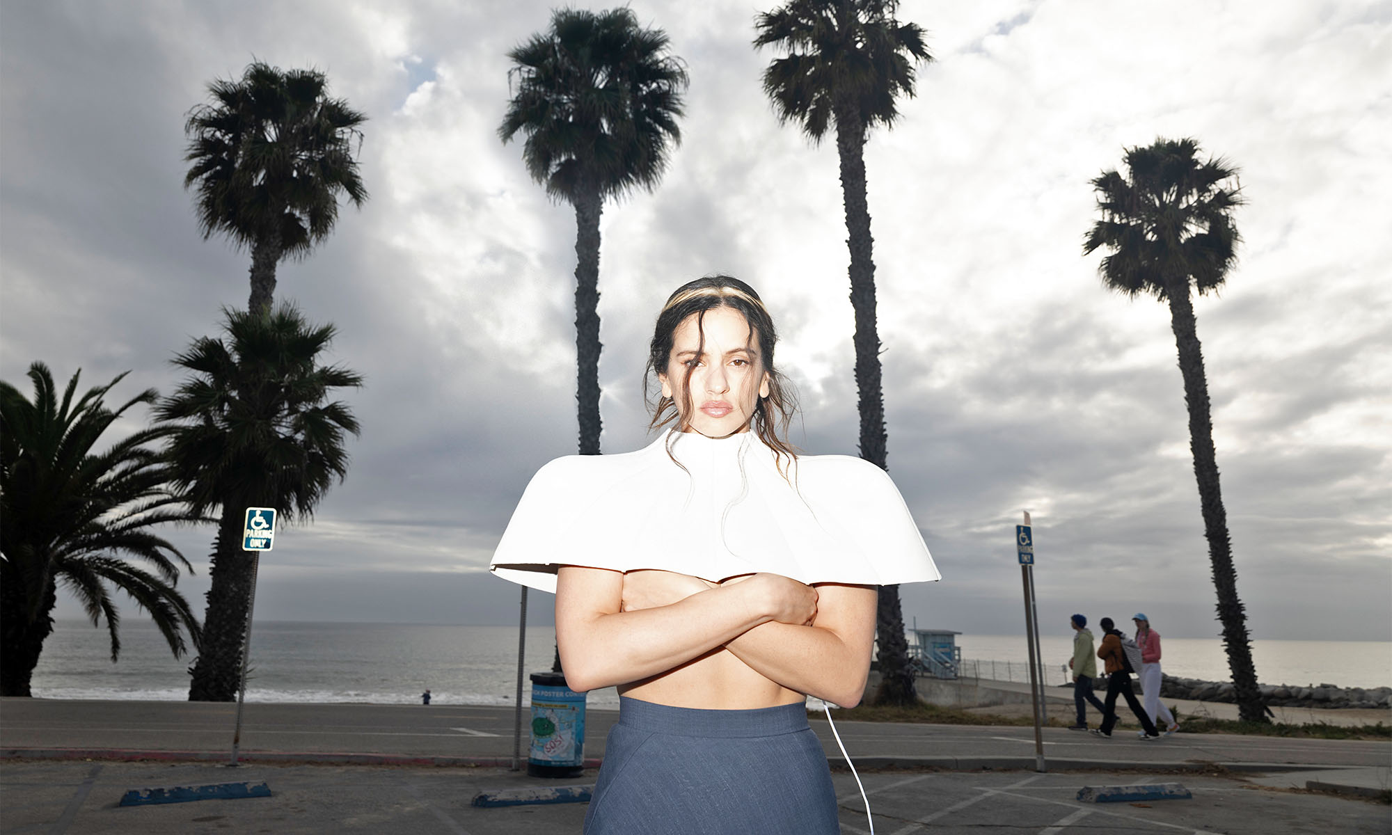 Die spanische Sängerin Rosalía steht vor Palmen.