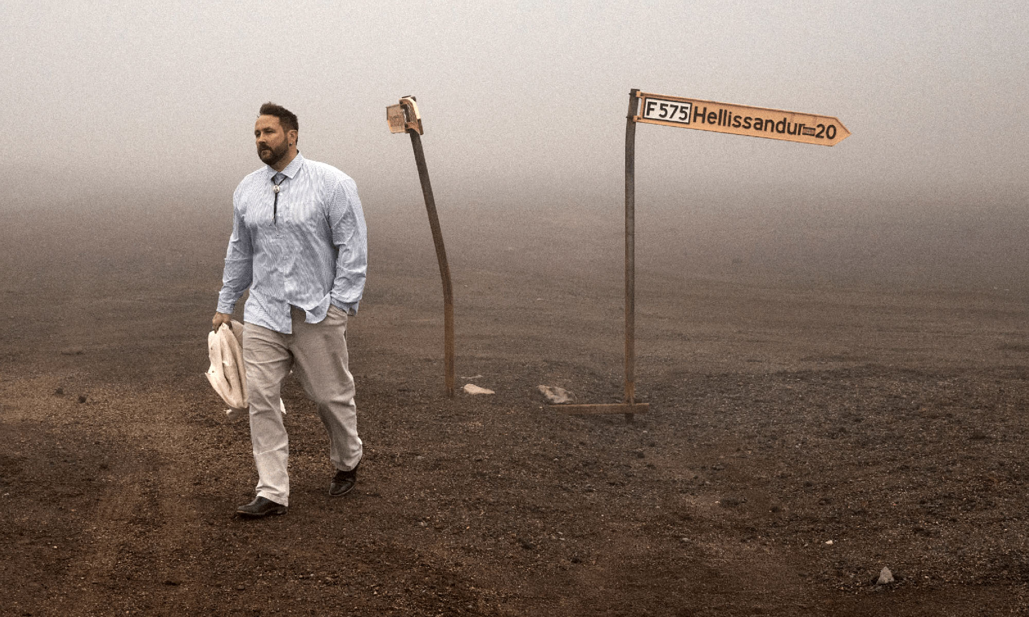 Der Sänger Florian Künstler geht über steinigen Untergrund, der Hrizont verschwindet im Nebel.
