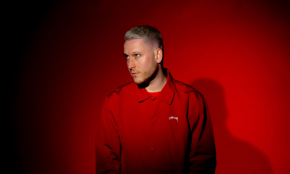 Der Kölner Rapper Mo-Torrs in roter Kleidung vor rotem Hintergrund.