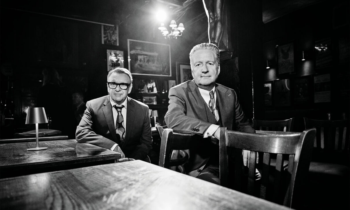 Zwei Musiker der britischen Band Squeese sitzen an einem Kneipentisch