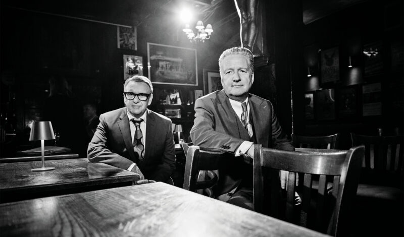 Zwei Musiker der britischen Band Squeese sitzen an einem Kneipentisch