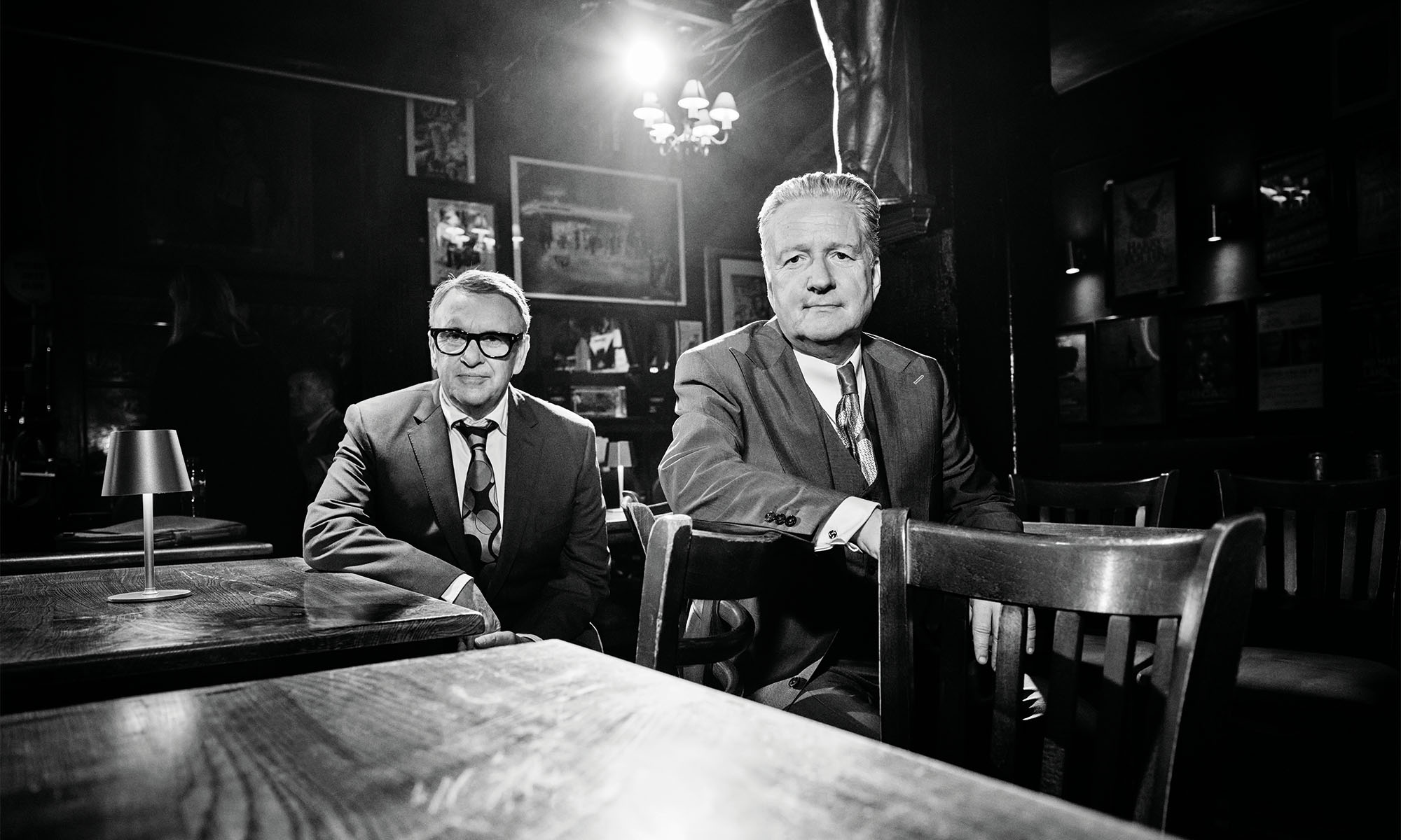 Zwei Musiker der britischen Band Squeese sitzen an einem Kneipentisch