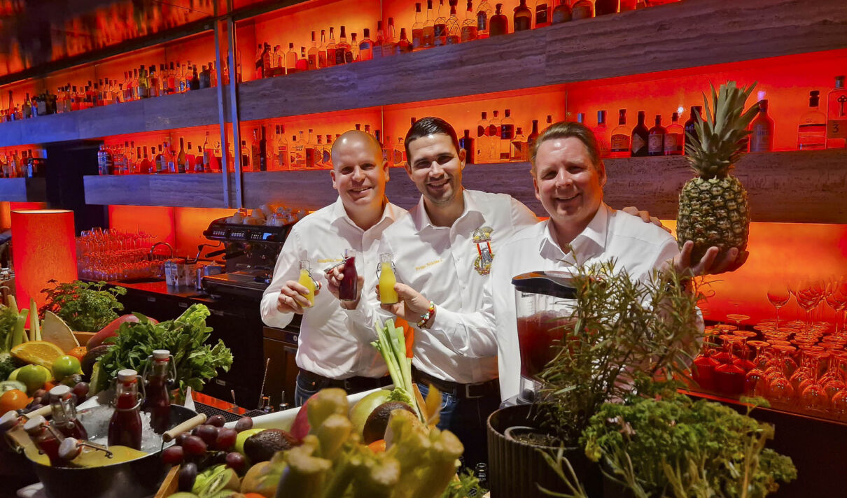 Jungfrau Aenne, Prinz Niklas I. und Bauer Clemens (v.l.n.r.) stehen hinter der Theke einer Bar.