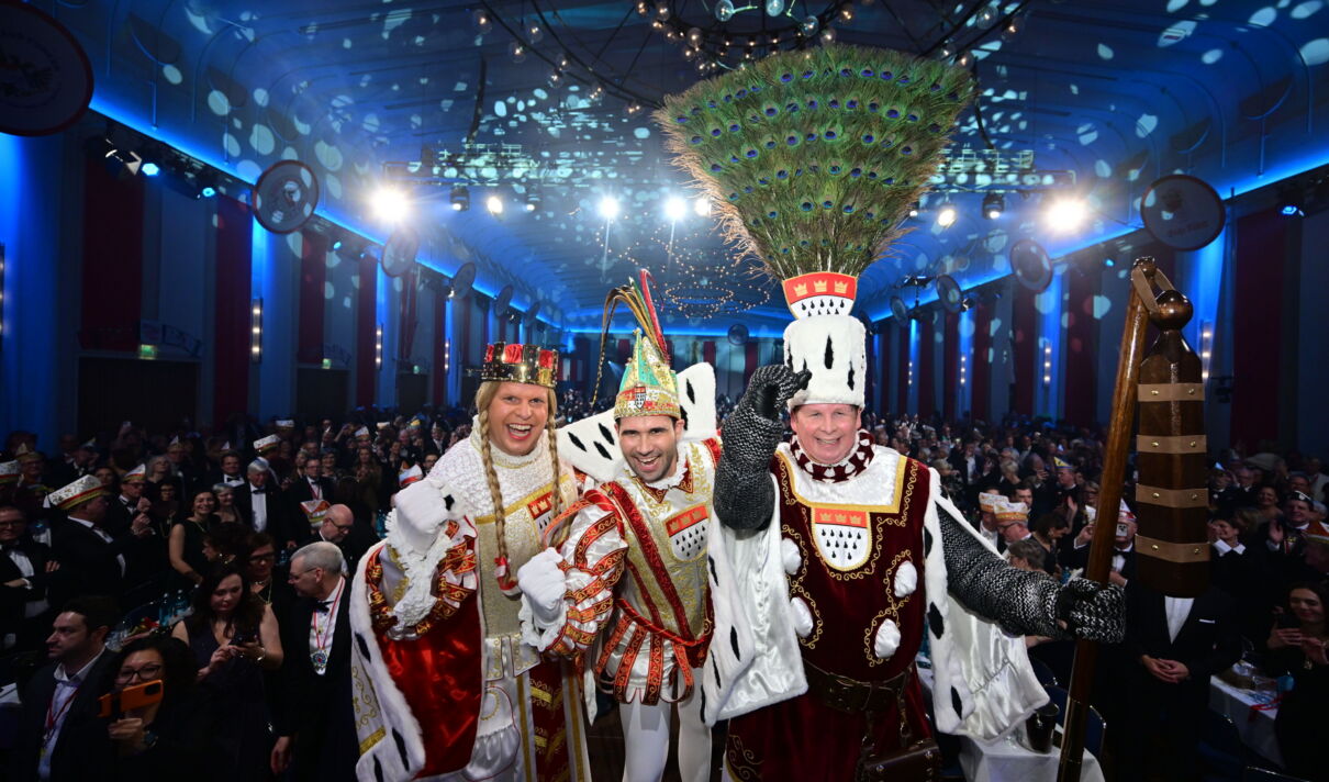 Das Foto zeigt Prinz Niklas I., Bauer Clemens und Jungfrau Aenne bei der Prinzenproklamation im Kölner Gürzenich.
