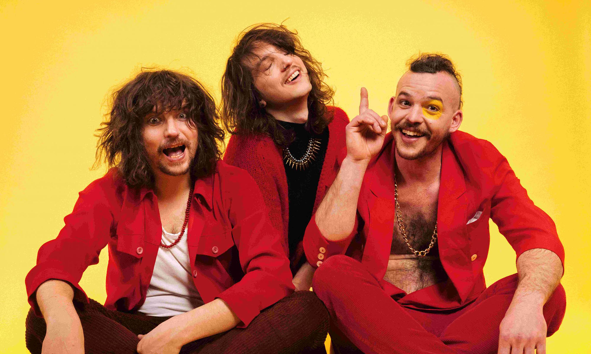 Die Musiker der österreichischen Psychedeloc-Rockband Mother's Cake in roter Kleidung vor gelbem hintergrund