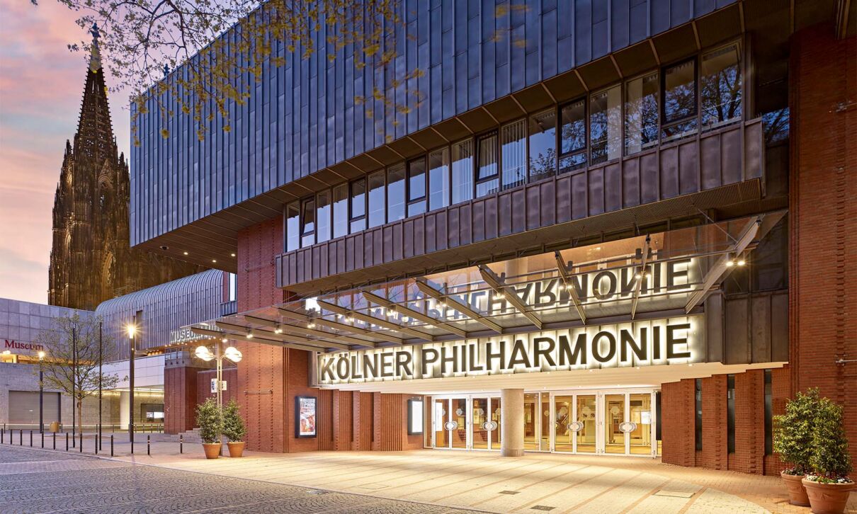Beleuchteter Eingang der Kölner Philharmonie in der Dämmerung