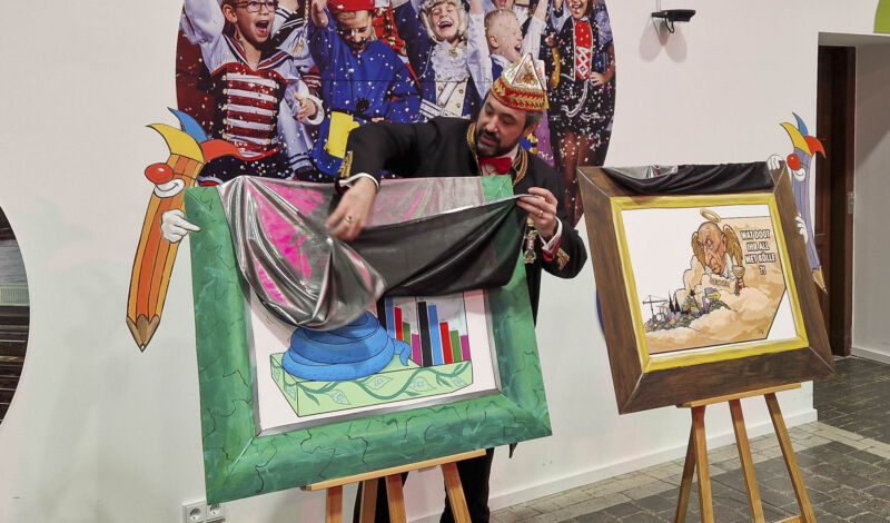 Zugleiter Marc Michelske präsentiert Motive von Persiflagewagen im Kölner Rosenmontagszug der Session 2026