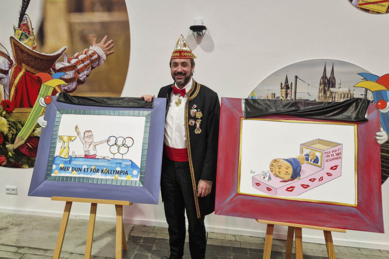 Zugleiter Marc Michelske präsentiert Motive von Persiflagewagen im Kölner Rosenmontagszug der Session 2026