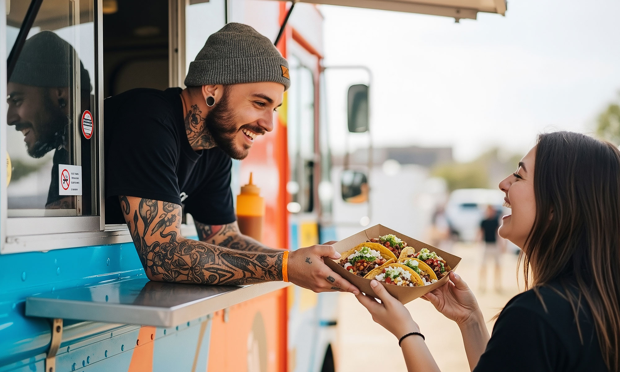 Ein Verkäufer reicht einer Kundin eine Schale mit Tacos