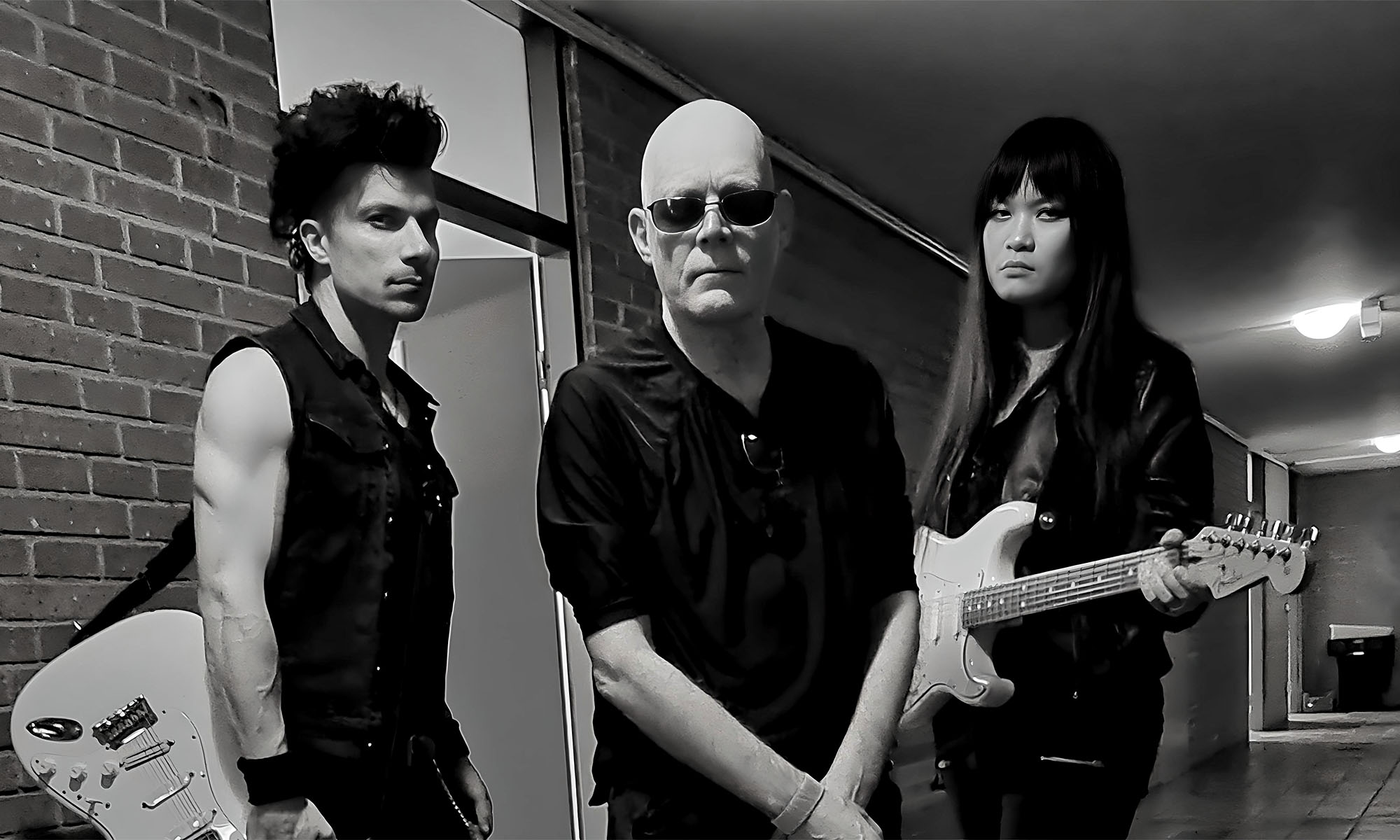 Andrew Eldritch (mi.) und zwei weitere Musiker der Band The Sisters of Mercy