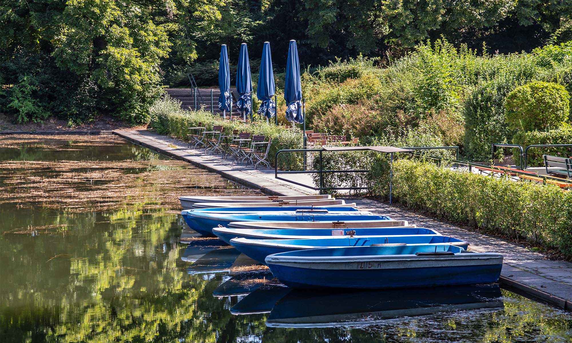 Boote liegen auf dem See im Blücherpark vor dem Biergarten