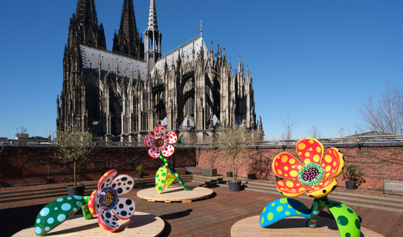 Kunstwerke der japanischen Künstlerin Yayoi Kusama mit dem Kölner Dom im Hintergrund