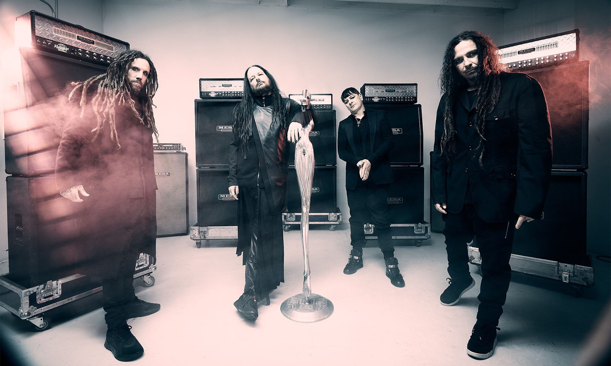 Musiker der Nu-Metal-Band Korn stehen vor Gitarrenverstärkern.