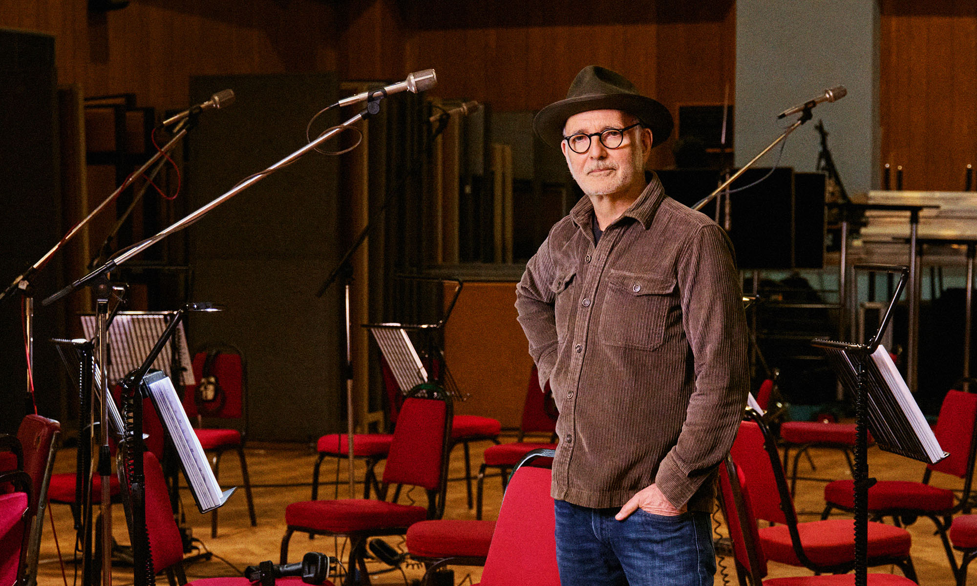 Der italienische Komponist und Pianist Ludovic Einaudi steht leger gekleidet in einem großen Studio.