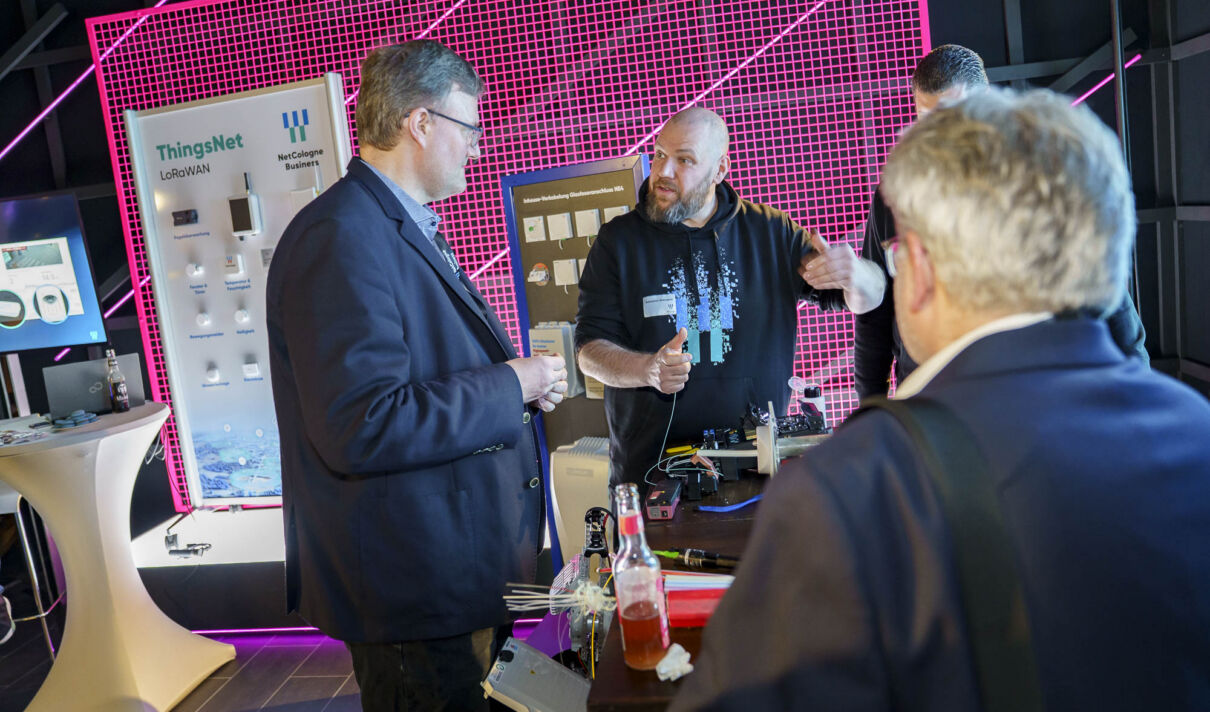 Ein Mitarbeiter von NetCologne erklärt einem interessierten Gast das Spleißen von Glasfaser