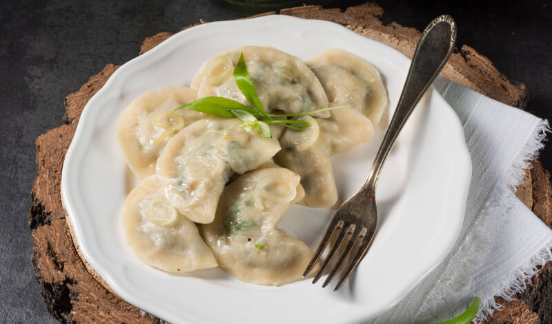 Mehrere Pierogi auf einem weißen Teller mit Gabel