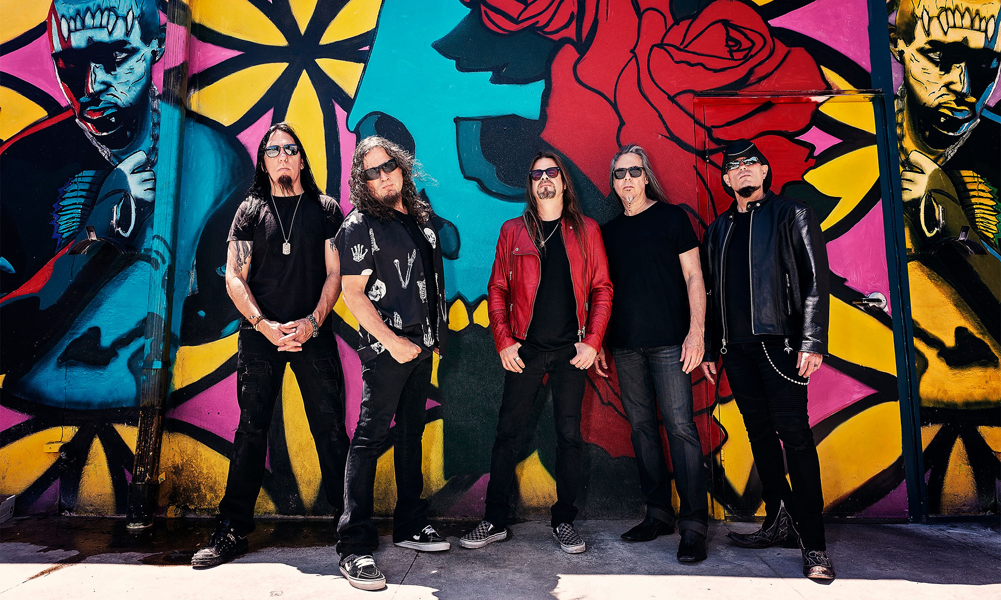 Die Musiker der Band Queensrÿche stehen vor einer Wand mit Graffiti