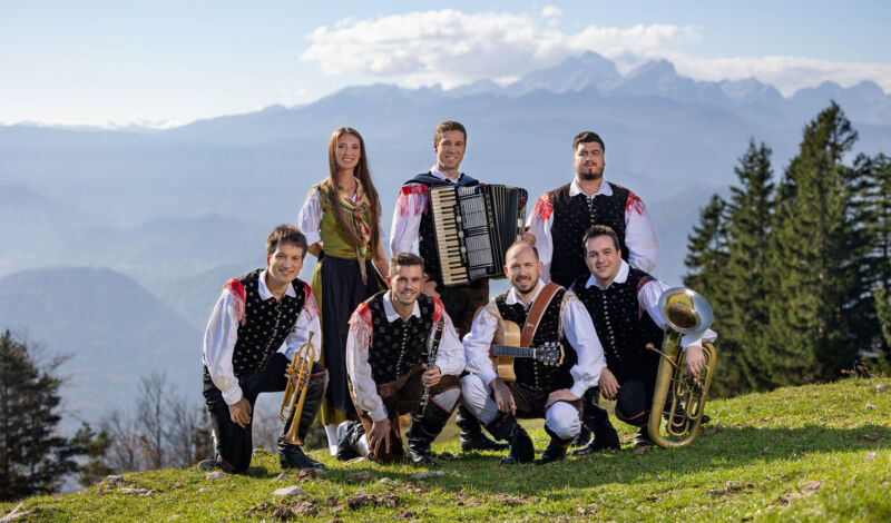 Die Blasmusik- und Volksmusikkapelle Saśo Avsenik & seine Oberkrainer vor einer Bergkulisse