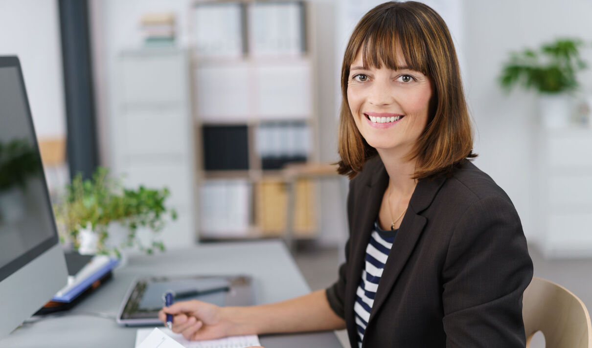 Eine Junge Frau im Büro an einem Bildschirmarbeitsplatz