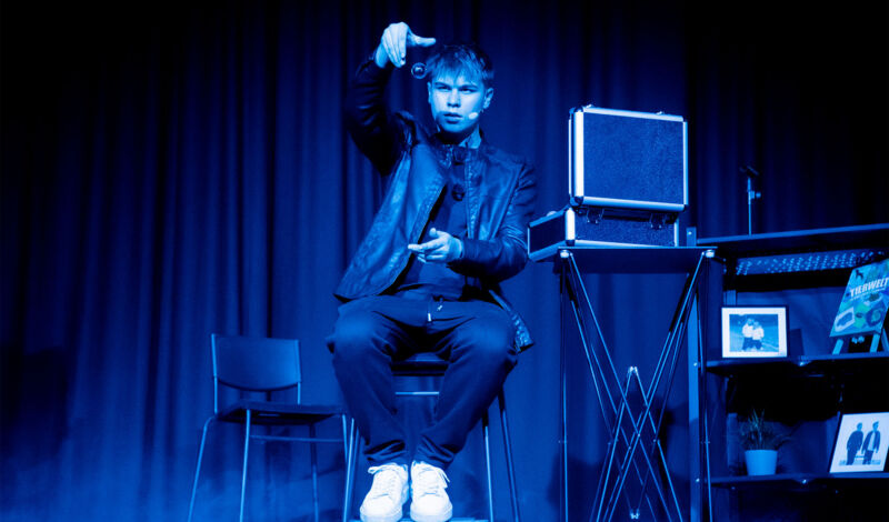 Ein Zauberer aus der Zaubershow twoMagic in bleuem Licht auf der Bühne