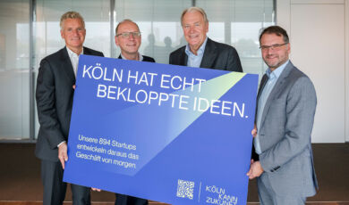 Frank Blase, Timo von Lepel, Gerald Böse und Andreas Feicht (v. l. n. r.) mit einem Kampagnenmotis von "Köln kann Zukunft"