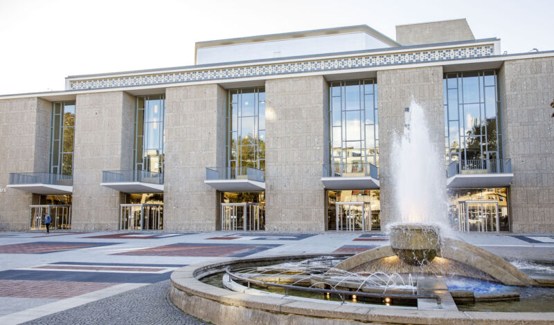 Die Kölner Oper am Offenbachplatz, im Vordergund ein Springbrunnen