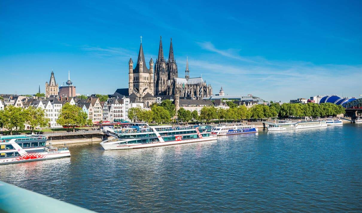Panorama Kölns mit Kölner Dom, Rhein und Schiffen am Anleger in der Altstadt.