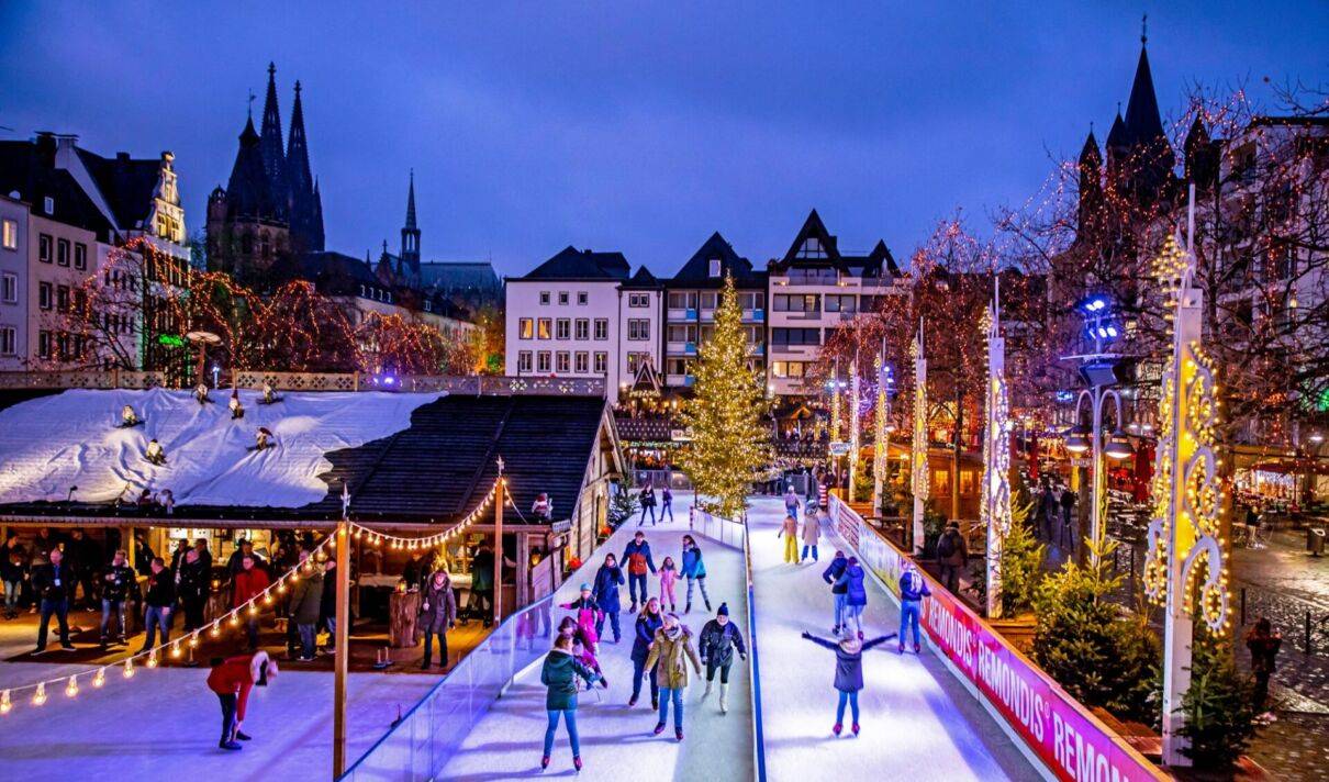 Das Bild zeigt eine Eislaufbahn auf dem Weihnachtsmarkt am Kölner Heumarkt.